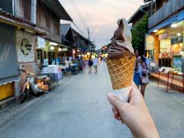 mano femenina sosteniendo helado de chocolate foto