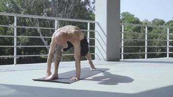 junger Mann mit vielen Tattoos macht Yoga-Übungen video
