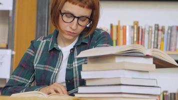 ung kvinna i glasögon läser en bok video