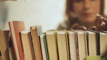 mujer elegir libros en el estante video