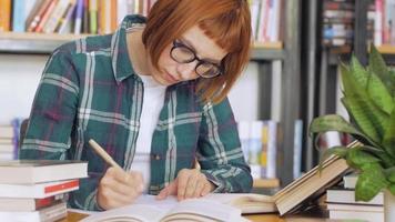 Jeune femme rousse à lunettes lit un livre video