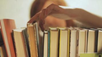 Young Woman Choose Books on Shelf video