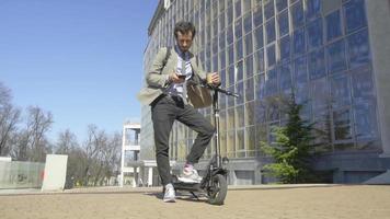 homem de negócios relaxando em uma scooter elétrica video