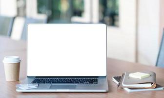 Close-up view of open blank screen laptop computer with office photo