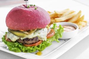 Beetroot red bun cheese burger snack set with fries and chili mayo on white plate photo