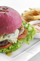 Beetroot red bun cheese burger snack set with fries and chili mayo on white plate