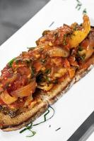 Portuguese caldeirada de peixe spicy tomato onion and peppers fish stew on rustic tiborna toast tapas style photo