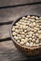 Organic kampot dried white pepper corns in Cambodia in Traditional Asian wood bowl photo