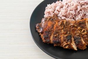 Pollo Jerk jamaicano picante a la parrilla con arroz - estilo de comida jamaicana foto