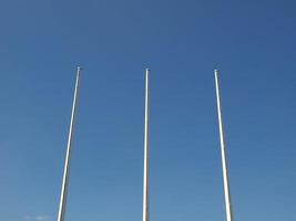 Flagpoles over blue sky photo