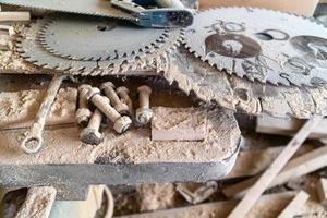 Hojas de sierra circular eléctrica y manual, polvo de madera en la mesa de carpintería foto