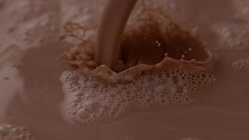 Chocolate milk pouring and splashing in slow motion video