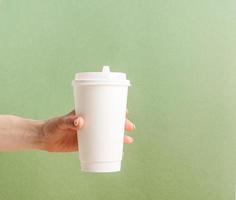 White large takeaway paper coffee cups mock up on green background photo