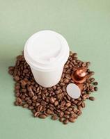 Eco-friendly disposable white paper cup with coffee beans and capsules photo