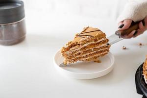 close up of woman hands cutting a cake photo