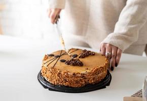 close up of woman hands cutting a cake photo