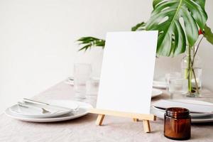 Menu or stand for booklet on restaurant table with tropical bouquet photo