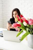 Woman communicating on the phone, focus on flowers photo