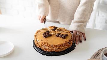 Close-up of woman's hands cutting a cake photo