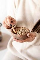 Woman's hand holding bowl with green coffee beans photo
