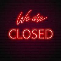 WE ARE CLOSED glow red neon font on brick wall background.