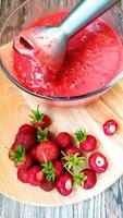 Processing strawberries with an electric blender photo