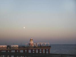 puesta de sol, faro en el paseo marítimo de la ciudad de adler foto