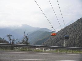 Carretera de montaña y teleférico en las montañas del Cáucaso. sochi, rusia foto