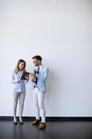 Young business people with tablet by the wall in the office photo