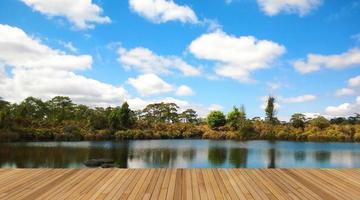 cubierta de madera con hermoso lago y cielo azul foto