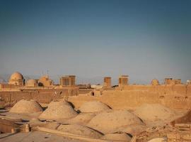 Downtown rooftops wind towers and landscape view of Yazd city old town in Iran photo