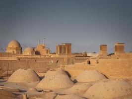 Downtown rooftops wind towers and landscape view of Yazd city old town in Iran photo