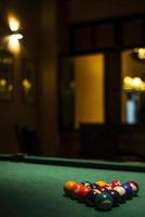 Billiards balls on pool table in cozy dark bar interior detail photo