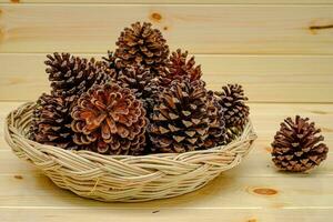 Dry pine cone placed in a tray on the wood table photo