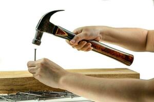 Hand hoiding hammer hitting a nail photo