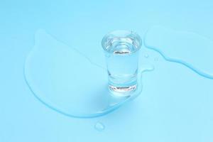 Vodka in shot glass on blue background photo