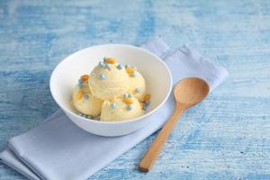 Vanilla ice cream on a blue background with a blank space for a text, vanilla ice cream in white ceramic cup
