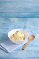 Vanilla ice cream on a blue background with a blank space for a text, vanilla ice cream in white ceramic cup photo