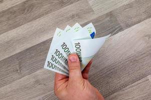 hand of man counting 100 euro banknotes photo