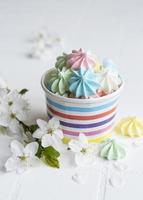 Small colorful meringues in the  paper bowl photo