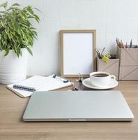 Laptop with office supplies on the table photo