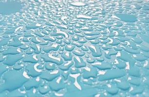 Abstract water droplets sparkling on light blue background photo