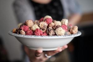 persona sosteniendo un tazón de palomitas de maíz dulces de colores foto