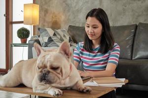 mujer linda asiática independiente casual que trabaja desde casa con su perro. foto