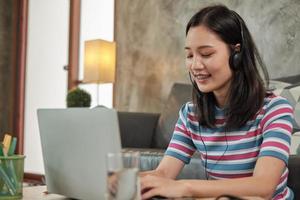 mujer asiática que usa la computadora portátil para el trabajo desde casa y el aprendizaje en línea.