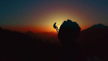 bergbeklimmer in silhouet bij zonsondergang