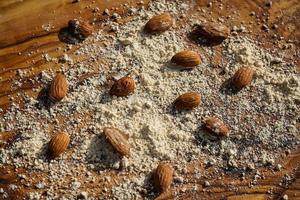 A pile of shelled almonds on olive wood photo
