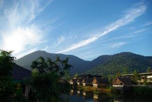 In the morning light small huts beside the lake and the mountain view photo