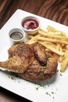 Roast rotisserie half chicken with french fries simple meal on white plate photo