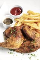 Roast rotisserie half chicken with french fries simple meal on white plate photo